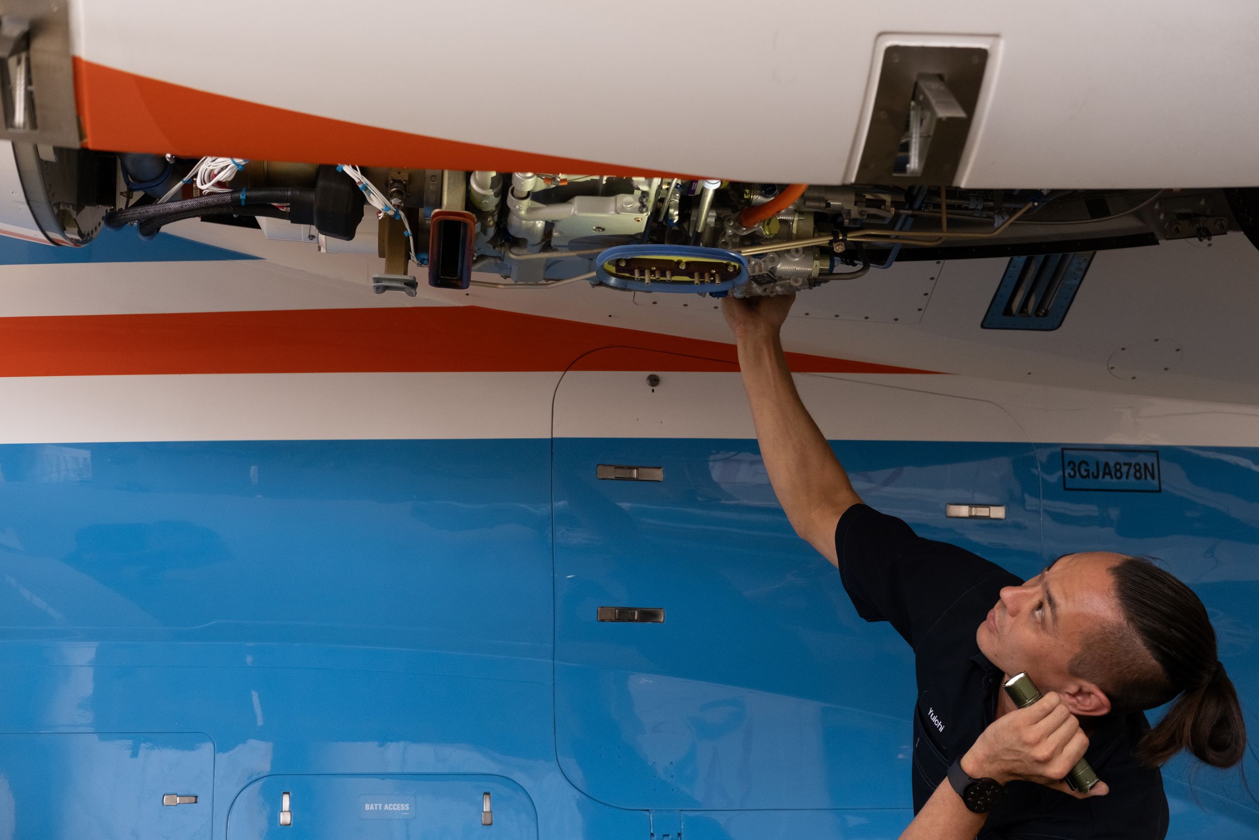 A Fly Alliance maintenance technician working on an aircraft panel